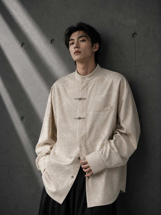 Person wearing a beige button-up shirt against a dark background