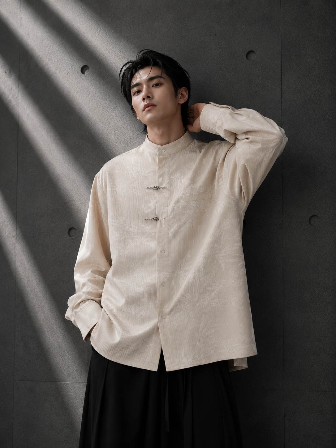 Person wearing a light-colored shirt against a dark background