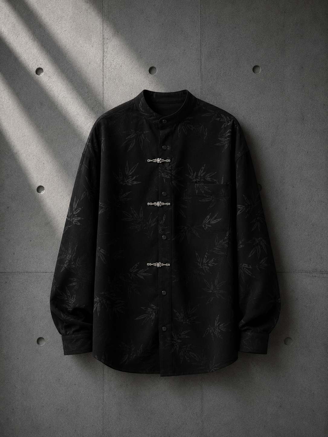 Black shirt with subtle pattern on a concrete wall