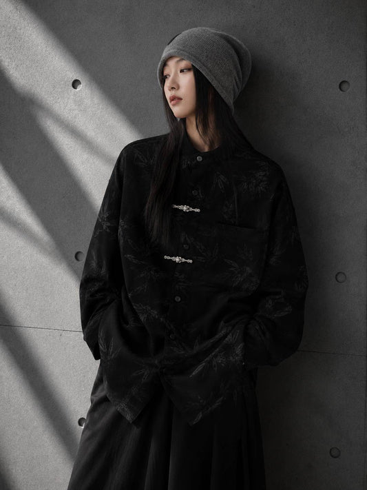 Person wearing a black jacket and gray beanie against a gray wall