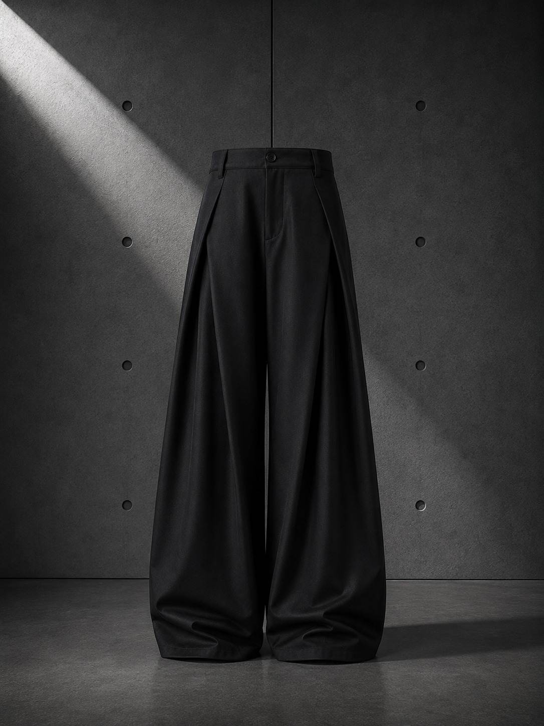 Black wide-leg pants against a textured gray wall.
