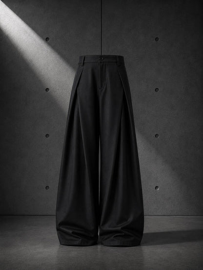 Black wide-leg pants against a textured gray wall.
