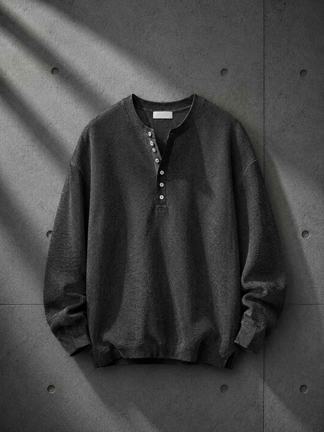 Dark gray sweatshirt on a textured gray background