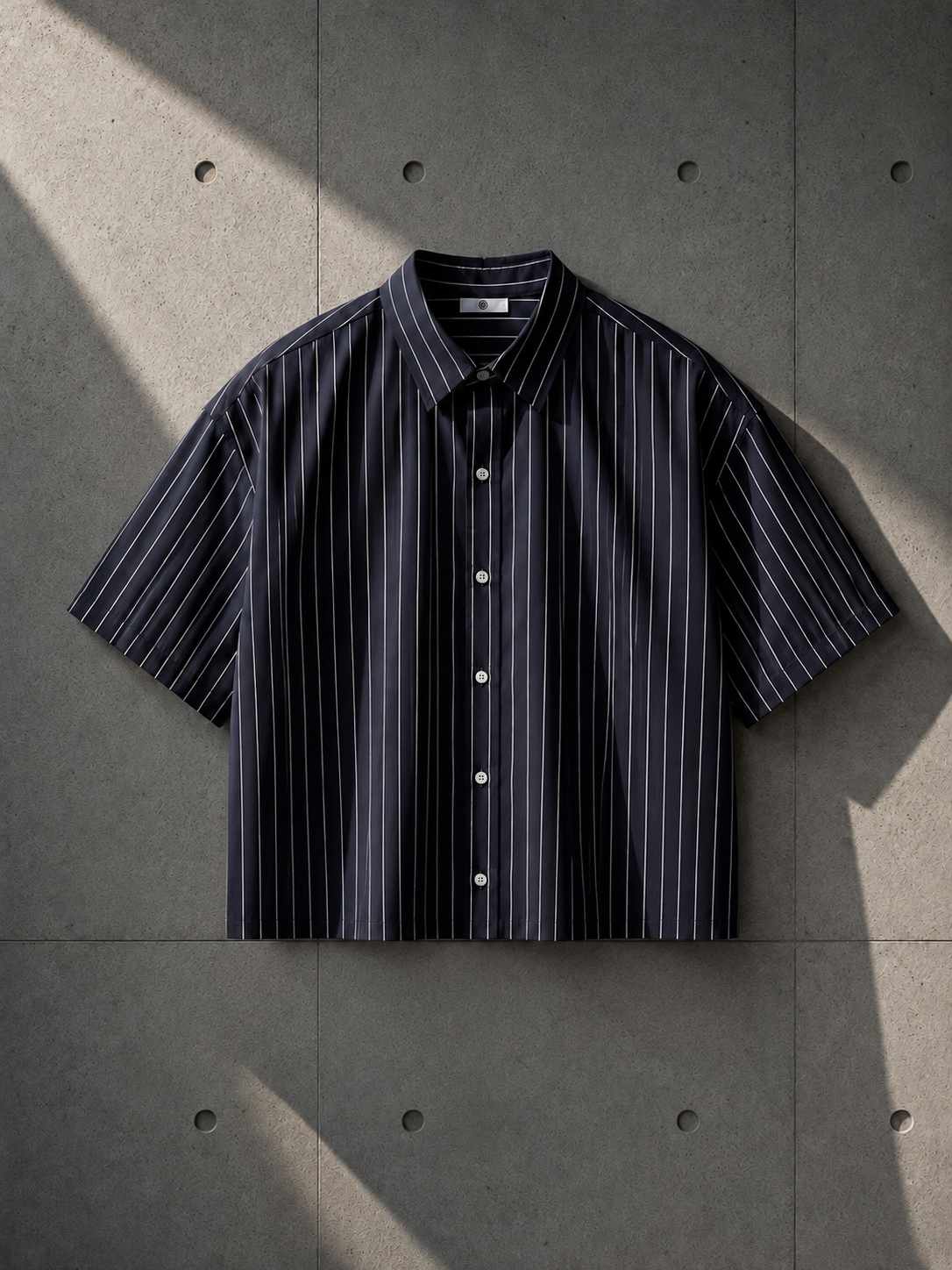 Navy striped shirt on a textured gray surface
