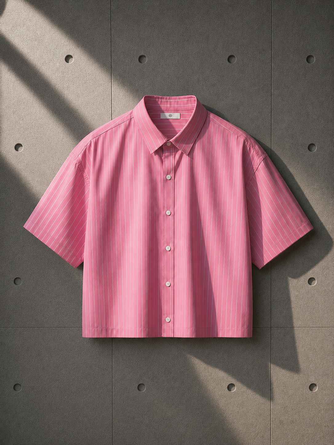 Pink short-sleeve shirt on a textured gray background
