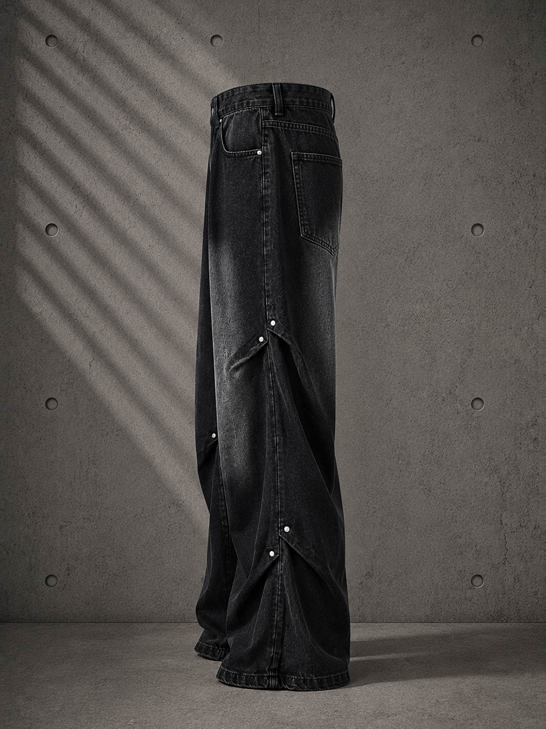 Black wide-leg jeans on a gray concrete background