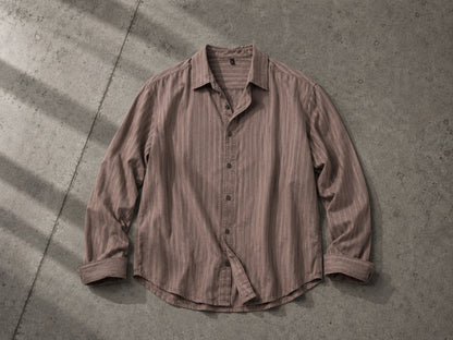 Brown stitch stripe button-up shirt flat lay on a gray concrete surface