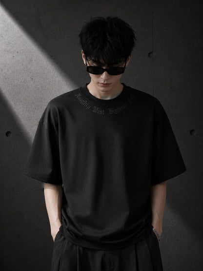 Person wearing a black t-shirt with text against a dark background