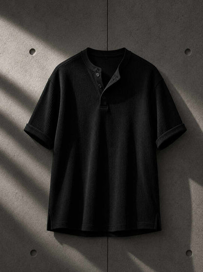 Black ribbed t-shirt on a textured gray background