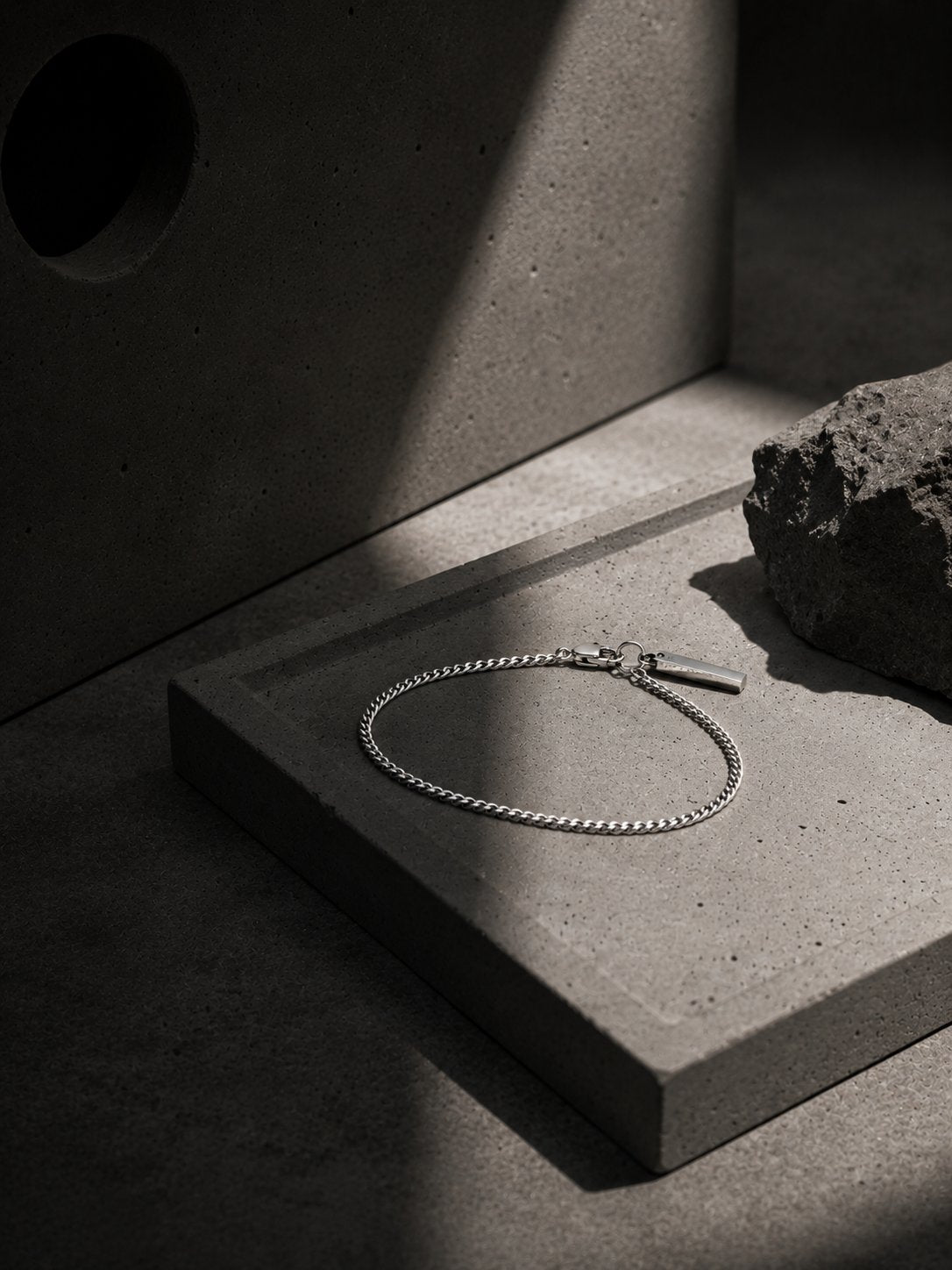 Silver bracelet on a concrete surface with a textured background