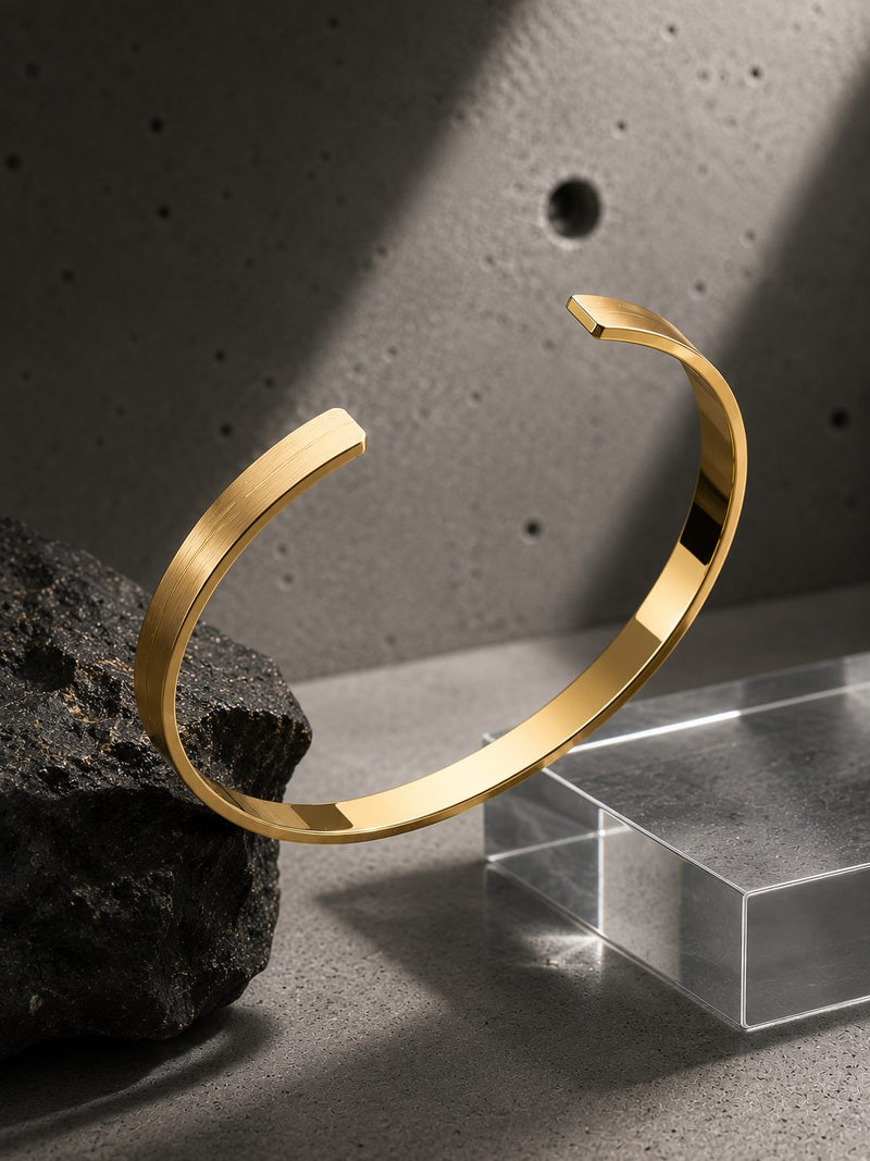 Gold bracelet on a gray surface with a textured background