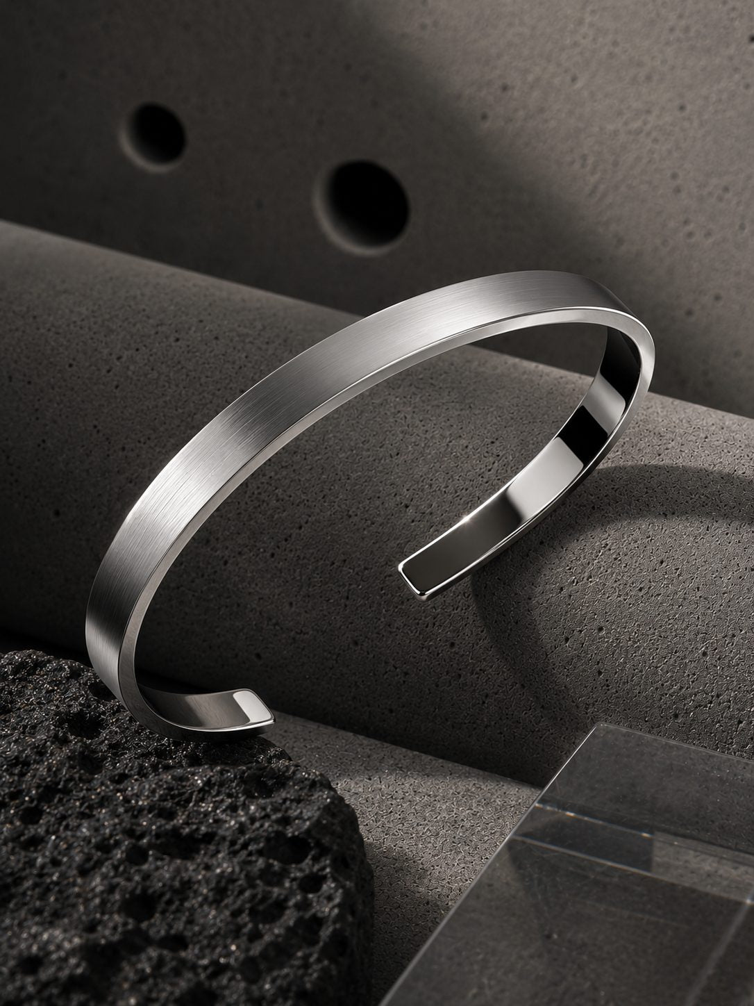 Silver bracelet on a textured surface with a dark background