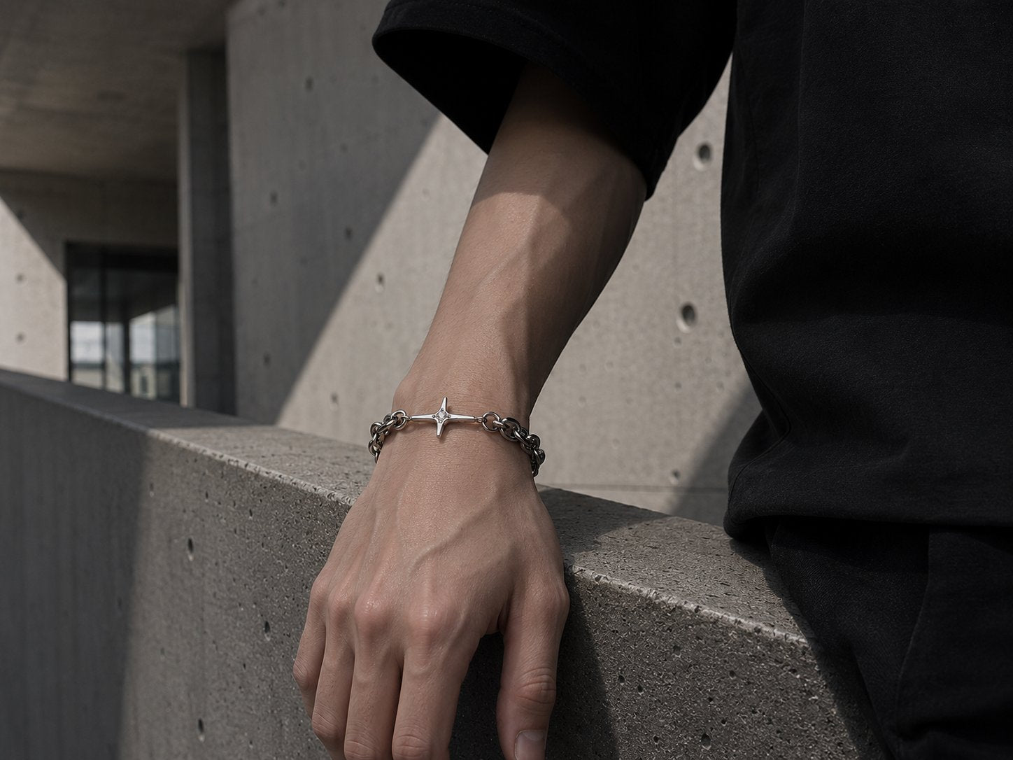 Person wearing a bracelet on a concrete surface