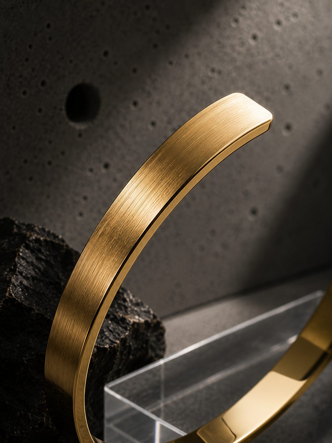 Gold bracelet on a textured surface with a dark background